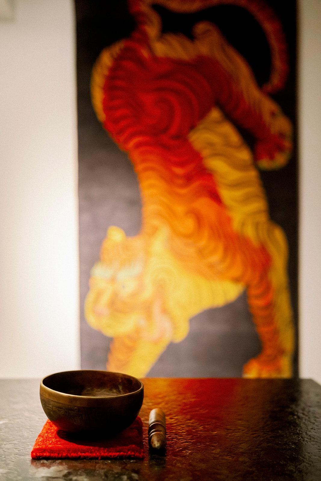 山赴地毯台灣茶席現場，茶碗與紅色地毯上的虎圖像彼此映照。