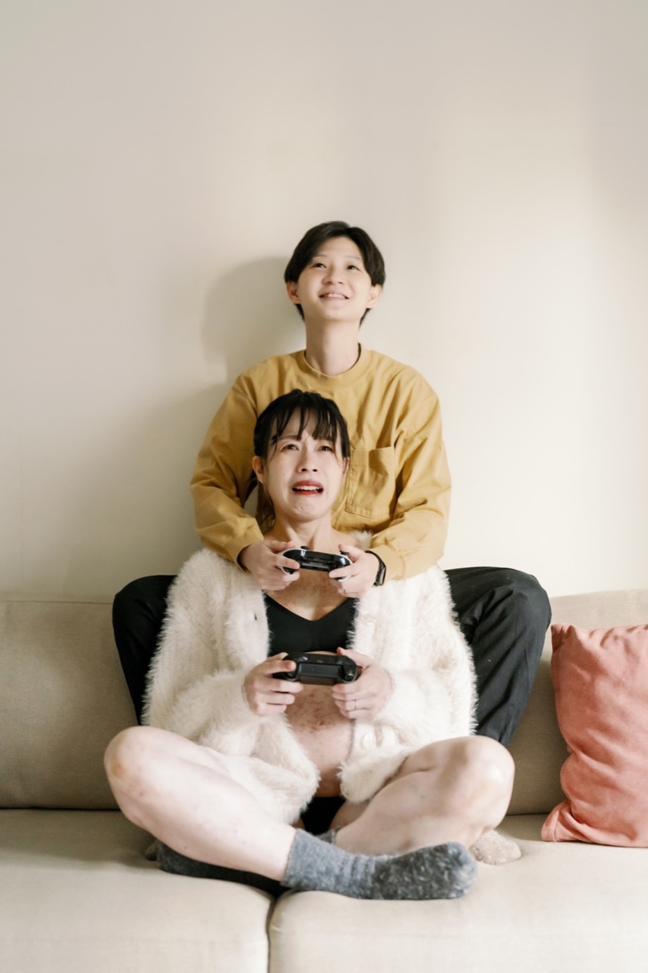 巫巫與恩如在家中沙發上一起拿著遊戲手把，拍攝孕婦影像。
