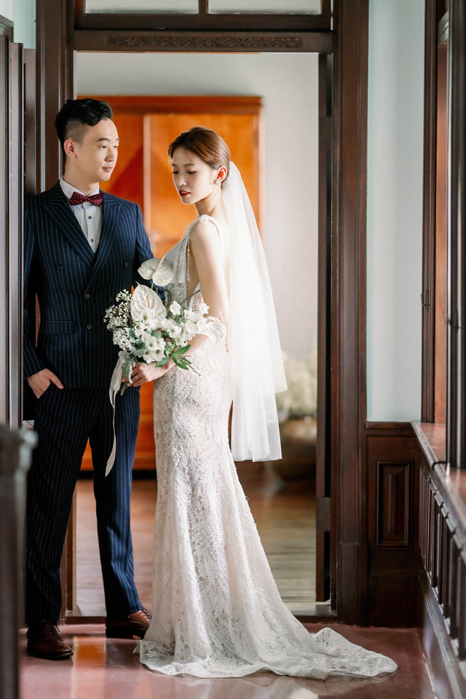Yuler 與 Hank 穿著婚紗禮服，在姜阿新洋樓的木質廊道中拍攝婚紗。